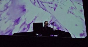Artist James Perley, resident at GlogauAIR summer 2018, performing live music piece in front of a visual backdrop.